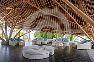 Tropical restaurant interior with sofas and pillows under wooden roof