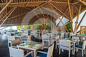 Tropical restaurant with wooden tables and chairs at luxury five stars resort