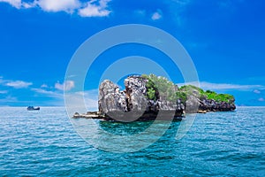 Tropical rock island against blue sky and sea