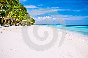 Tropical sandy beach at Panglao Bohol island with Sme Beach chairs under palm trees. Travel Vacation. Philippines