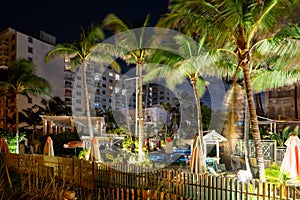 Tropical scene at night Savoy Hotel Miami Beach pool deck with palm trees