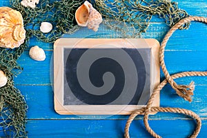 Tropical sea background. Different shells, old fishing net on the blue boards, top view. Free space for inscriptions on the slate