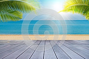 Tropical sea beach with sand, ocean, palm leaves and blue sky