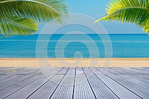 Tropical sea beach with sand, ocean, palm leaves and blue sky