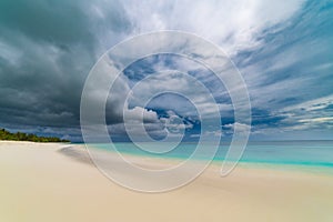 Tropical sea and beach sunset. Cloudy sky and soft waves of the ocean. Colorful twilight mood on a tropical island landscape