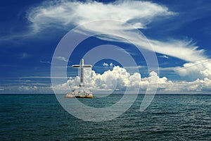 Tropical seascape with cross and clouds.