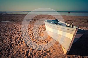 Tropical Seascape with a fishing boat on beach on warm sunset, S