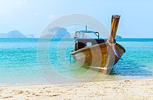 Tropical seascape with old fishing boat on beach.