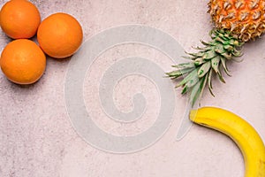 Tropical and Seasonal Summer Fruits. Pineapple Oranges and Bananas Arranged in corner of backgrounds, Healthy Lifestyle. Flat Lay