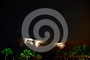 The thunderstorm over the shoreline provides a lightning display for those on the beach photo