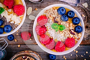 Tropical smoothie bowl with raspberries, blueberries, granola and coconut