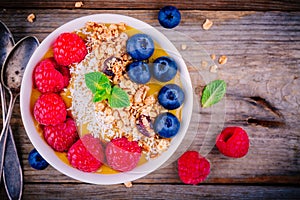 Tropical smoothie bowl with raspberries, blueberries, granola and coconut