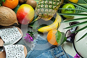 Tropical Summer Fruits Pineapple Mango Bananas Coconut on Large Palm Tree Leaf. Women Jeans Shorts Slippers Hat Sunglasses
