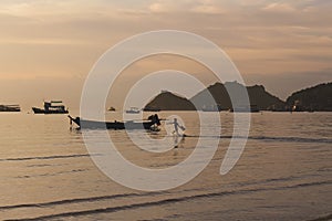 Tropical sunset in the beach with kid running