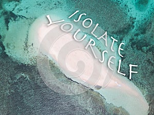 Tropical uninhabited island atoll with a sign `isolate yourself`