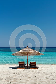 tropical vacation background. Sundbeds under the sun shade on sandy tropical beach