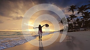 Tropical vacation on paradise island beach. Happy woman in dress enjoying sea sunrise