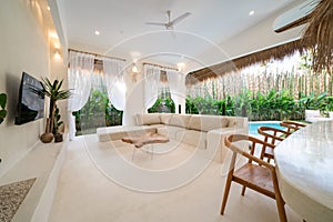 Tropical villa view with garden, swimming pool and open living room. Luxury modern villa