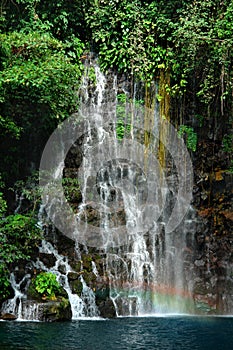 Tropical waterfall detail with rainbow.