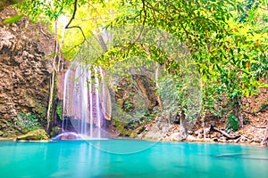 Tropical waterfall with emerald lake in jungle forest