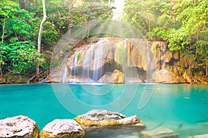 Tropical waterfall with emerald lake in jungle forest