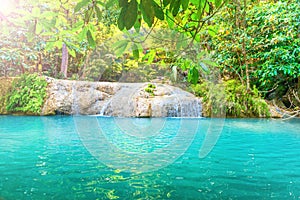 Tropical waterfall with emerald lake in jungle forest