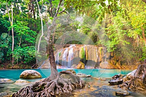 Tropical waterfall with emerald lake and rocks in jungle forest