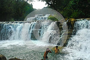 Tropical waterfall, swimming boys.