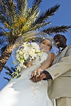 Tropical wedding couple holding hands