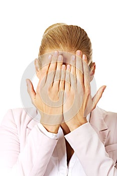 Troubled business woman covering her face with hands