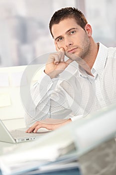 Troubled businessman sitting at desk