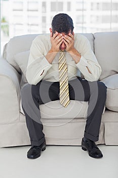 Troubled businessman sitting on sofa