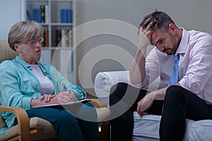 Troubled businessman talking with psychiatrist