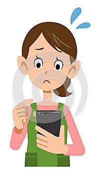 Troubled face of a woman wearing an apron to operate a smartphone