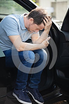 Troubled man sat in car with door open