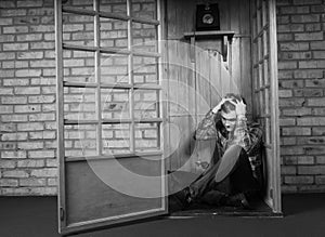 Troubled Man Sitting on Floor of Telephone Booth