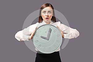 Troubled woman with clock on grey background. Time management concept