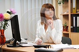 Troubled woman holding pen above calculator