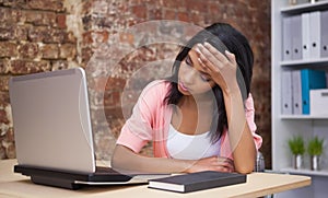 Troubled woman sitting at his desk with a laptop