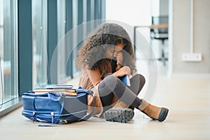 Troubles at school. Lonely sad african-american schoolgirl crying at school hall. Social exclusion problem. Bullying at