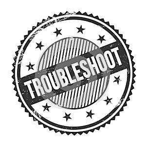 TROUBLESHOOT text written on black grungy round stamp