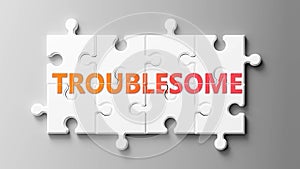 Troublesome complex like a puzzle - pictured as word Troublesome on a puzzle pieces to show that Troublesome can be difficult and photo