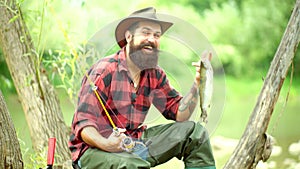 Trout. Handsome fisherman fishing in a river with a fishing rod. Steelhead rainbow trout. Portrait of cheerful man