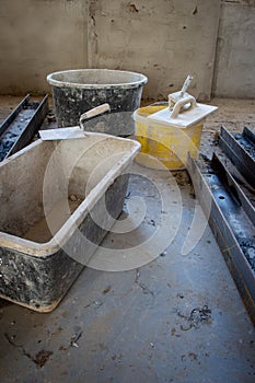 Trowel lies on the edge of a mortar box on a building site