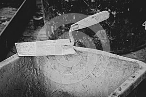 Trowel lies on the edge of a mortar box on a building site