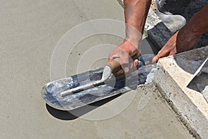 Troweling fresh concrete on a garage foundation with a trowel left  on the surface