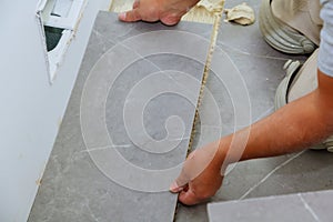 Troweling mortar a concrete floor in preparation for laying floor tile