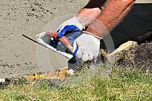 Troweling wet concrete on a sidewalk project