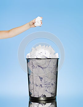 Trowing a paper into a wastebasket