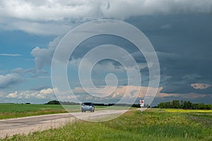 Truck approaching with looming storm clouds, Saskatchewan, Canad